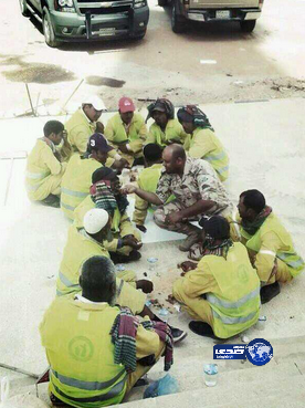 صورة رائعة لجندي سعودي يطعم عمال النظافة ويشاركهم طعامهم ( ماأجمل التواضع)