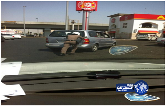 رجل مرور يساعد سائقاً في تحريك سيارته التي تعطّلت في منتصف الطريق