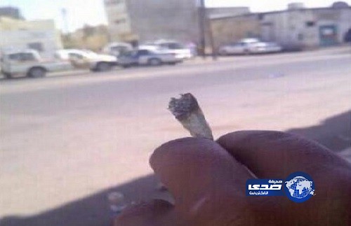 مغردون يتناقلون صورة لشخص يمسك بسيجارة &#8220;حشيش&#8221; أمام الدوريات في تبوك