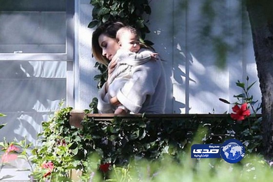 بالصور.. كيم كارداشيان تداعب إبنتها بحنان بين الورود