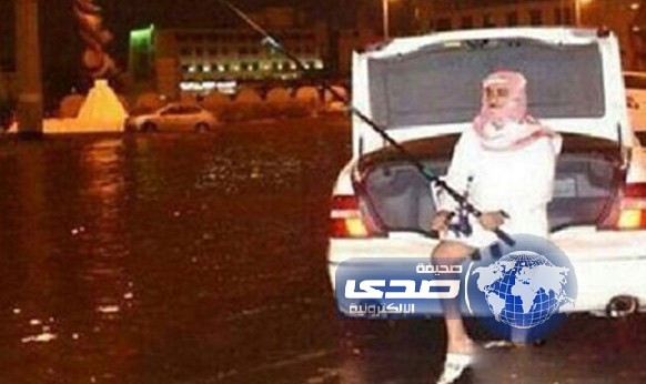 مواطن يستغل فيضانات المطر ليمارس هوايته المفضلة في صيد الاسمالك في الشوارع