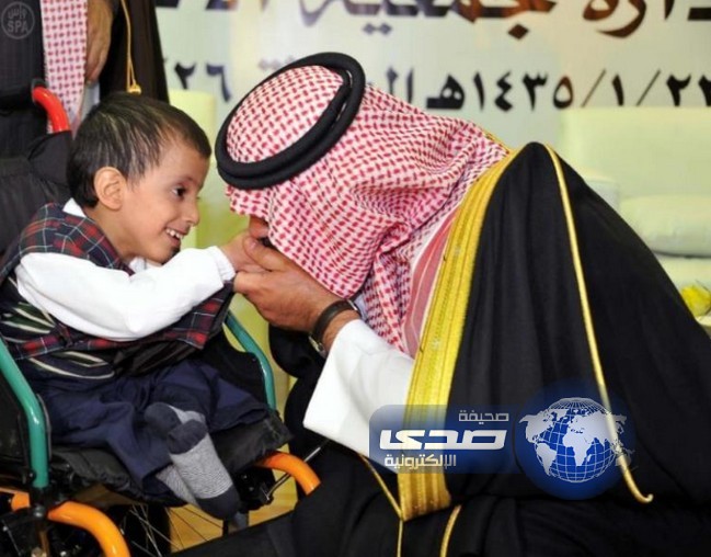 صورة لأمير الباحة خلال تقبيله طفلاً معاقاً في أبوية حانية