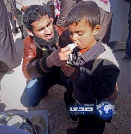 النجم الرياضي السابق سعد الحارثي يطعم طفل سوري أثناء زيارتهم للاجئين السورين في الاردن