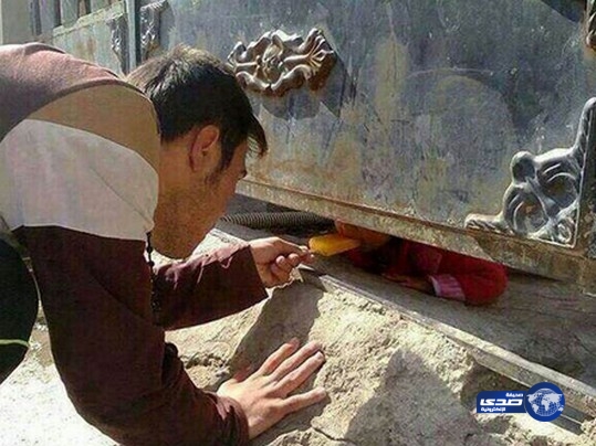 يُطعم الطفلة من تحت الباب لطمأنتها