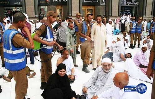 تلطيفاً للجو.. عسكري يقوم برش رذاذ الماء على زوار الحرم المكي حيث بلغت درجات الحرارة أرقاماً قياسية.