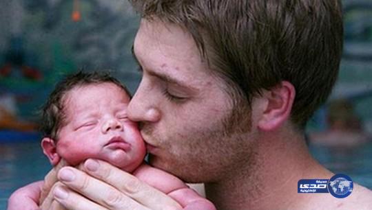 رجل يعلم ابنه السباحة بعد يوم واحد فقط على ولادته