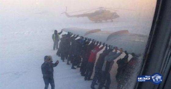 ركاب يدفعون طائرة تجمدت في الثلوج