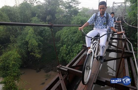 بالصور: طلاب يواجهون الموت يومياً بعبور أخطر طريق مدرسي في اندونيسيا