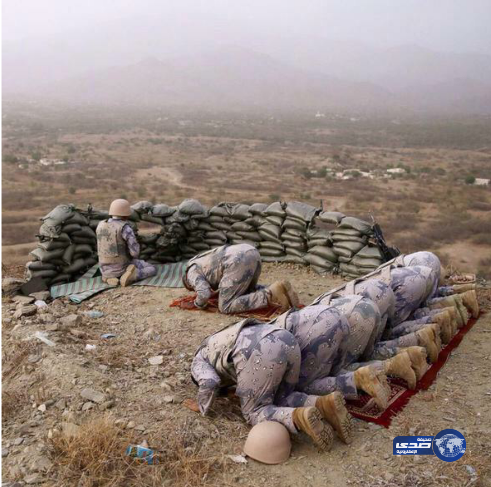 مغردون يتداولون صورة لجندي يحمي زملاءه وهم يؤدون الصلاة بالحد الجنوبي‎