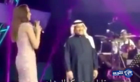بالفيديو: موقف طريف لمحمد عبده أثناء وقوف مذيعة أطول منه على المسرح