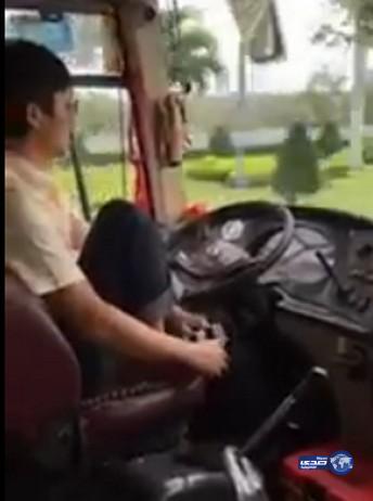 سائق حافلة يرتدي جواربه وحذاءه وهو يقود