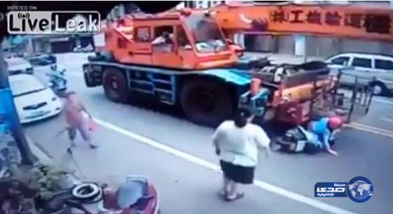 بالفيديو: امرأة تنجو من الدهس تحت عجلات ونش ضخم بأعجوبة