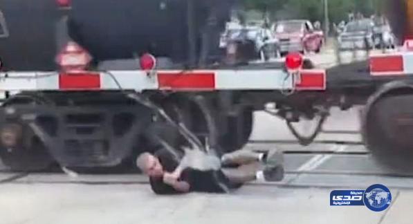 بالفيديو: رجل يخاطر بحياته ويعبر من تحت قطار متحرك