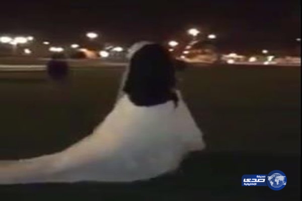 بالفيديو.. عريس بالبشت وعروسه بفستان الزفاف يتجولان في حديقة بالقصيم