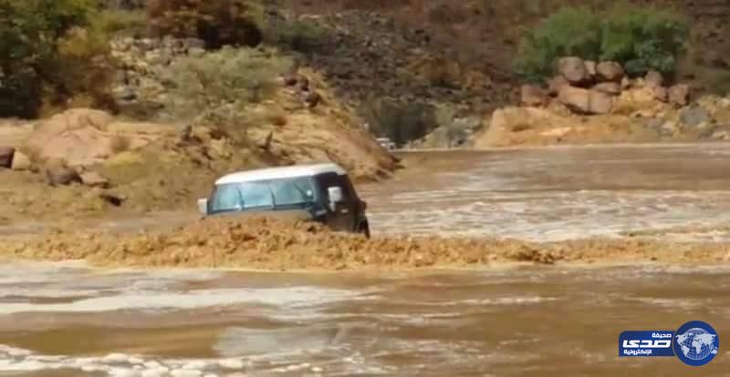 بالفيديو و الصور ..  قائد سيارة يعرض نفسه للخطر و يعبر سيول وادي شواص