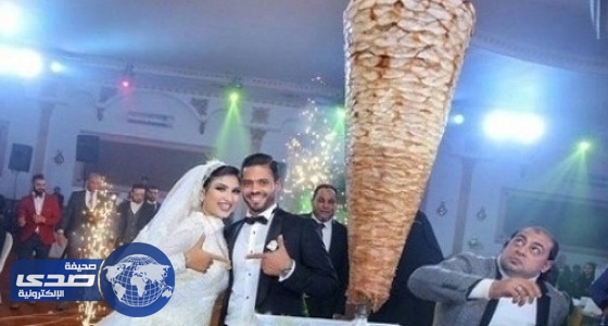 بالصورة.. عروسان يستبدلان قالب الحلوى بسيخ شاورما في حفل زفافهما
