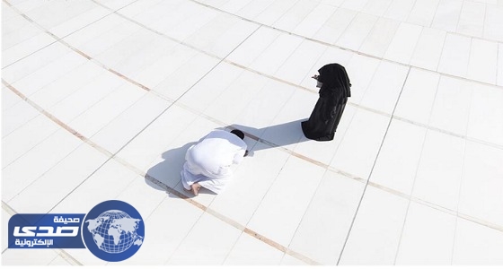 امرأة تظلل على زوجها من أشعة الشمس بالمسجد الحرام
