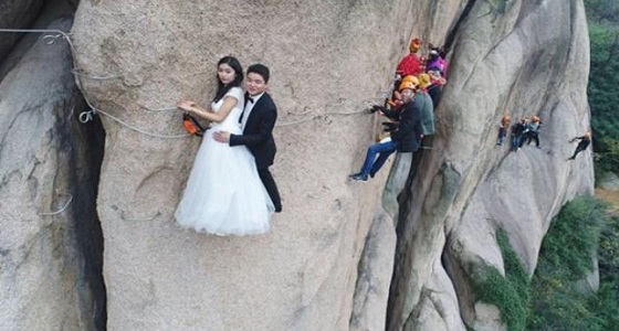 بالصور.. جلسة تصوير لعروسين صينيين أعلي جبل تشايا