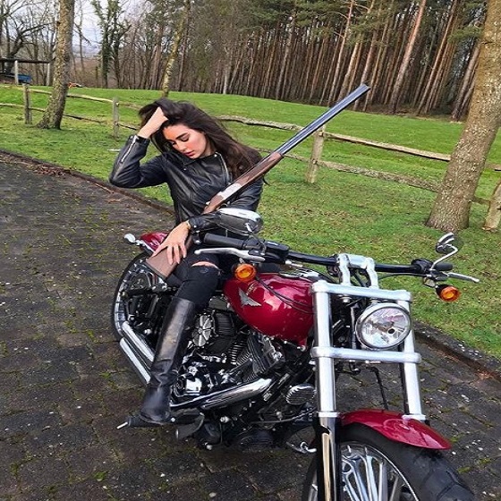ياسمين صبري تقود دراجة نارية وتحمل في يدها ” بندقية “
