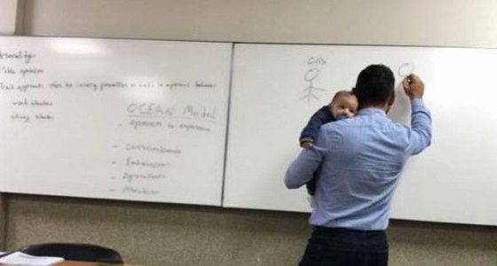 صورة أستاذ جامعي يحمل طفلاً بالمحاضرة تسرق القلوب