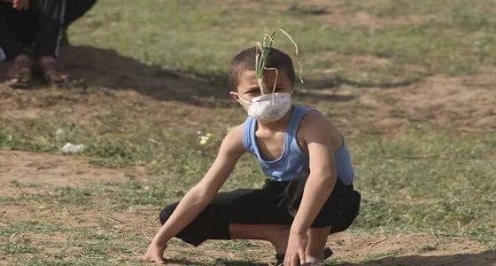 طفل فلسطيني يستخدم ” بصلة ” ليحمي نفسه من قنابل الغاز