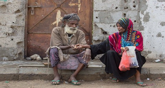 صورة لامرأة يمنية تتقاسم رغيف خبز مع عجوز رغم الفقر