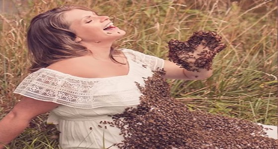 بالصور..امرأة تشارك فرحة حملها مع النحل وتضعه على بطنها