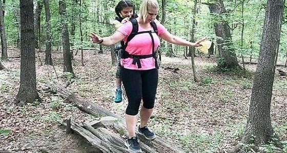 معلمة تحمل طالبة على ظهرها في رحلة مدرسية لمدة يومين