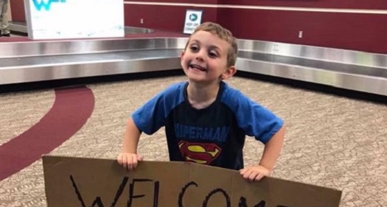 طفل يستقبل والدته في المطار بلافتة محرجة