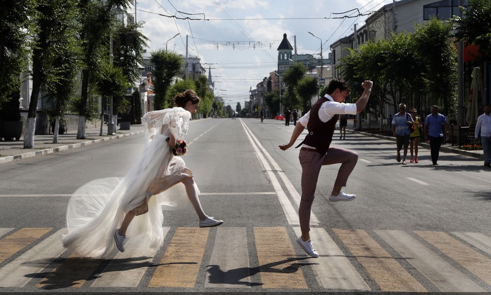 متزوجان جدد يعبران الطريق خلال إقامة بطولة كأس العالم &#8221; روسيا-2018 &#8221; في مدينة سامارا