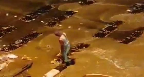 بالفيديو.. عامل نظافة يباشر عمله وسط السيول والأمطار