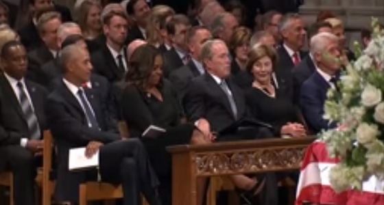 بالفيديو.. بوش يعطي زوجة أوباما قطعة حلوى أثناء جنازة ماكين