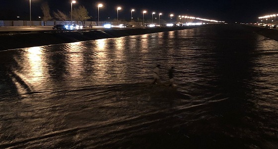بالصور.. شباب يعبرون مجرى السيول غير مكترثين للمخاطر