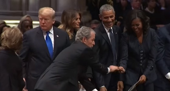 بالفيديو.. تكرار موقف غريب من بوش الابن مع زوجة أوباما بجنازة والده