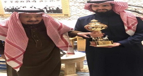 الملك سلمان يلتقط صورة مع ابنه سعود بعد فوز الفرس مجتاحة بكأس الملك فهد