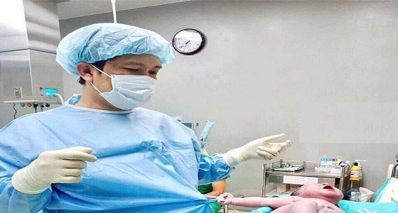 صورة طريفة لمولود يجذب ملابس طبيب الولادة بشدة