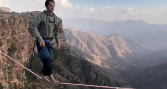 بالفيديو.. مشاهد تحبس الأنفاس لمغامر يسير على حبل بين جبال الحبلة بأبها