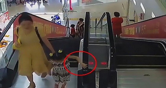 بالفيديو والصور.. سلم كهربائي يسحب يد طفلة صغيرة بمركز تجاري وشخص ينقذها