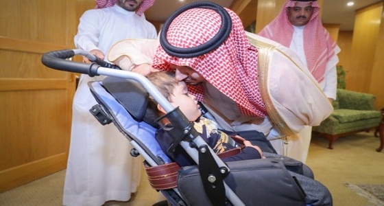 في موقف أبوي.. نائب أمير الجوف يحمل طفلة معاقة لمشاهدة حكام المملكة (صور)