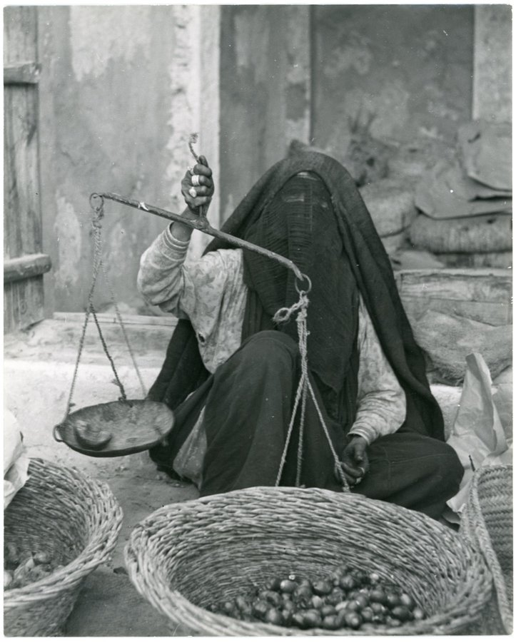 صورة نادرة لامرأة تزن التمور بسوق الظهران