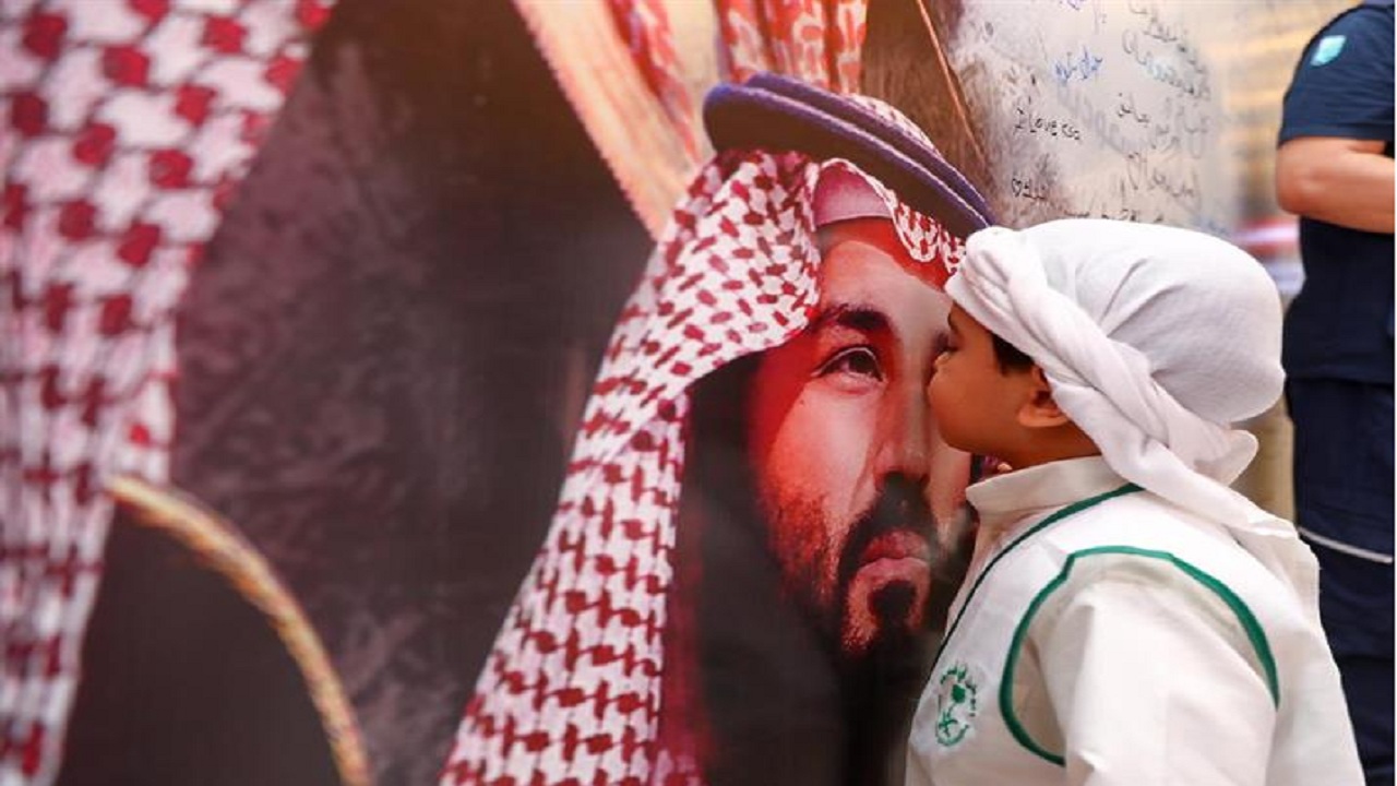 طفل يقبل صورة ولي العهد الأمير محمد بن سلمان بطريقة عفوية