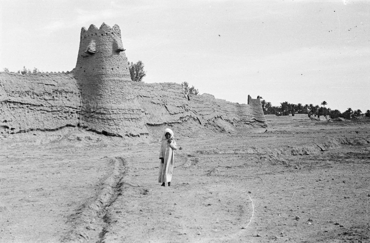 صورة لطفل يقف أمام الأسوار المحيطة بمحافظة مرات في الرياض