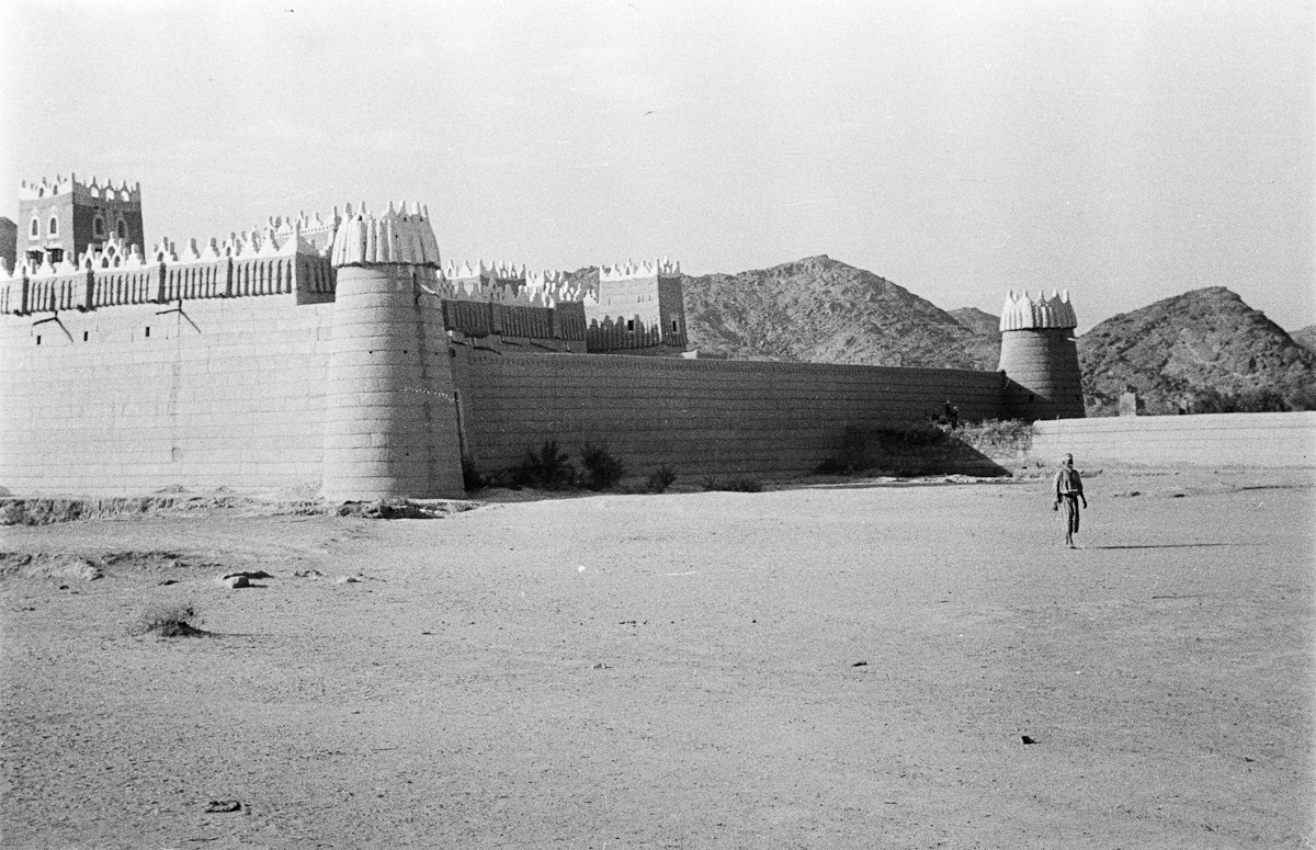 صورة قديمة لرجل يقف بجانب قصر إمارة نجران
