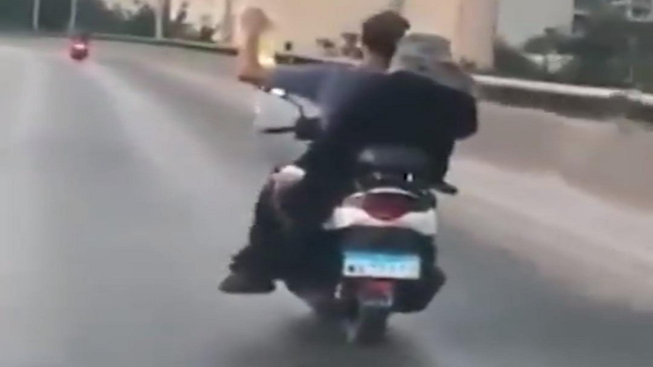مشهد مأساوي لشخص يقود دراجة ويحمل مصل لمريضة خلفه بلبنان