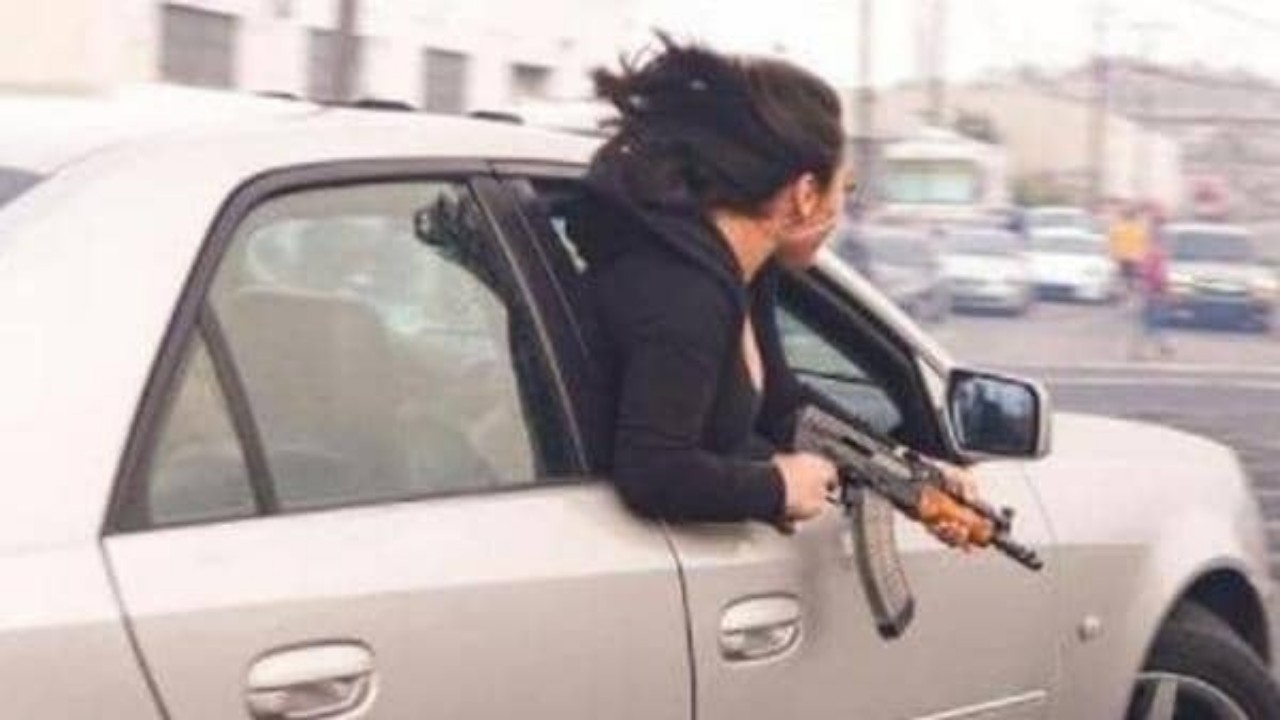 فتاة تحمل “كلاشينكوف” وتخرج جسدها من سيارة مسرعة تثير الجدل