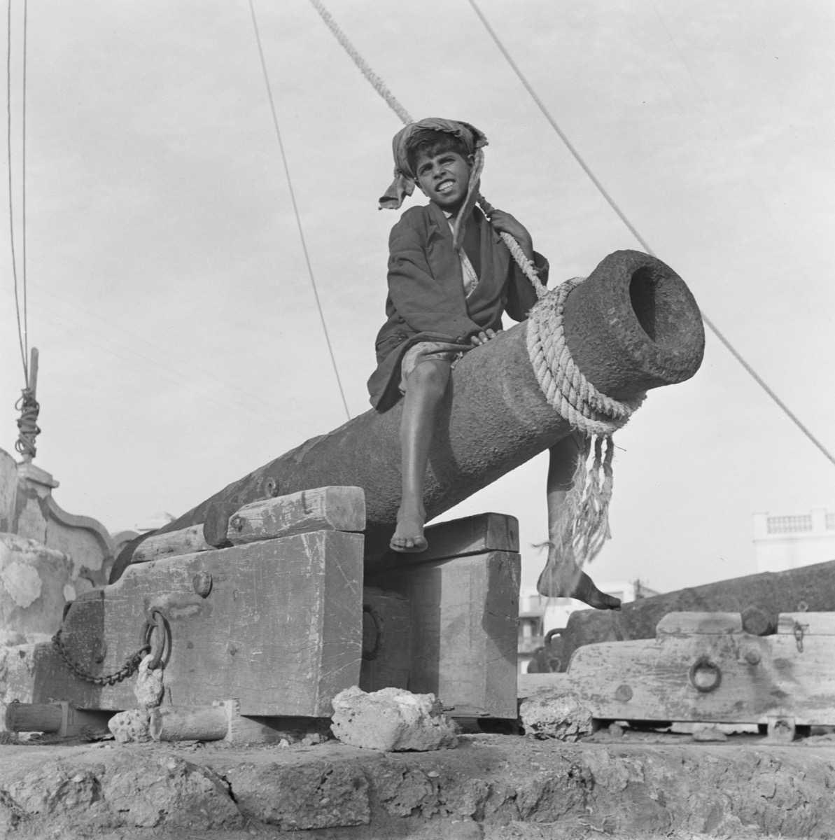 صورة رائعة لصبي يجلس فوق مدفع في ميناء الدمام