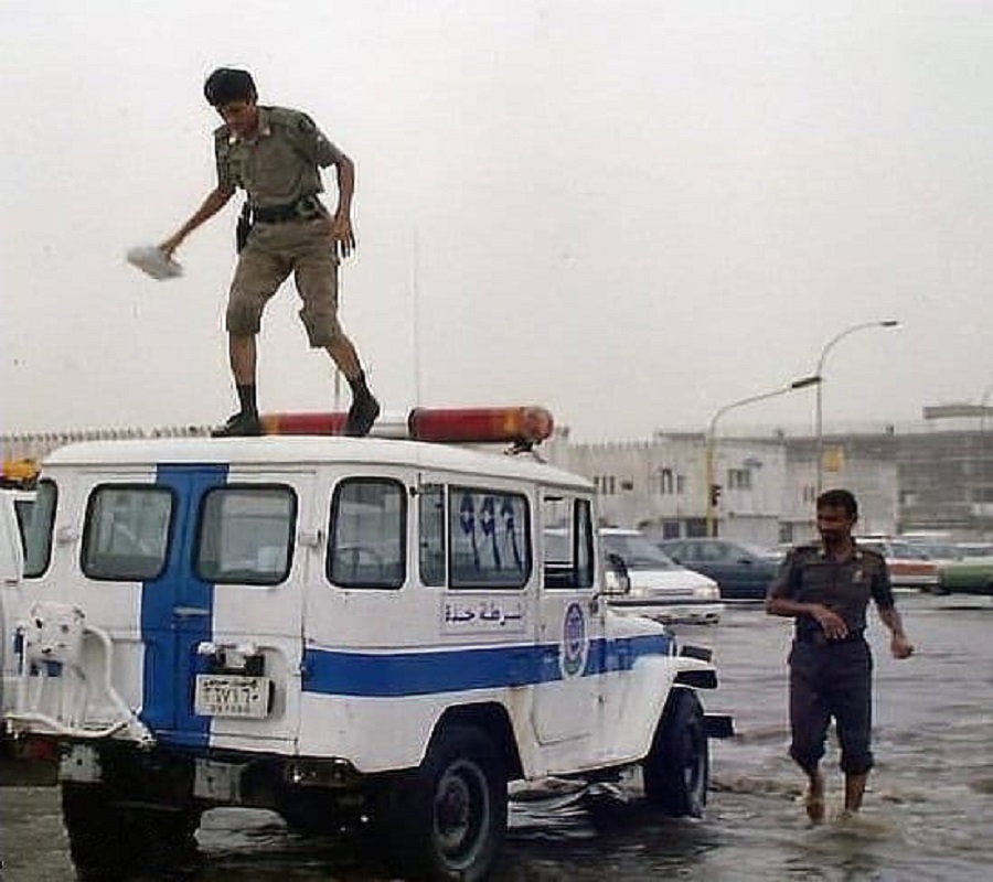 إثنان من أفراد الشرطة بعد هطول أمطار على جدة قبل 30 عام