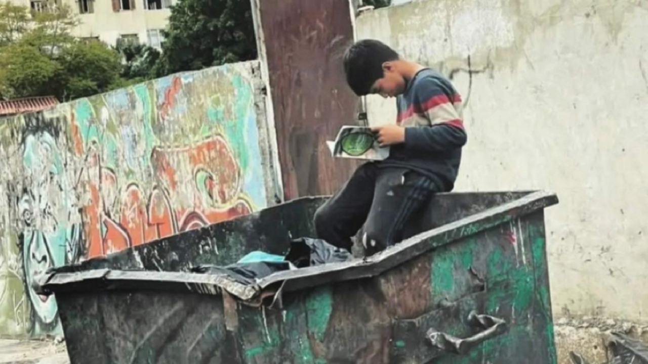 طفل سوري يثير ضجة بتصفحه كتابًا وسط القمامة في لبنان