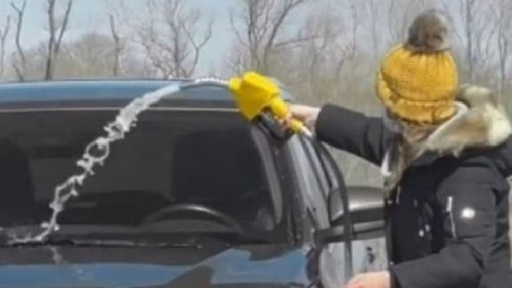 فتاة تغسل سياراتها بمضخة البنزين