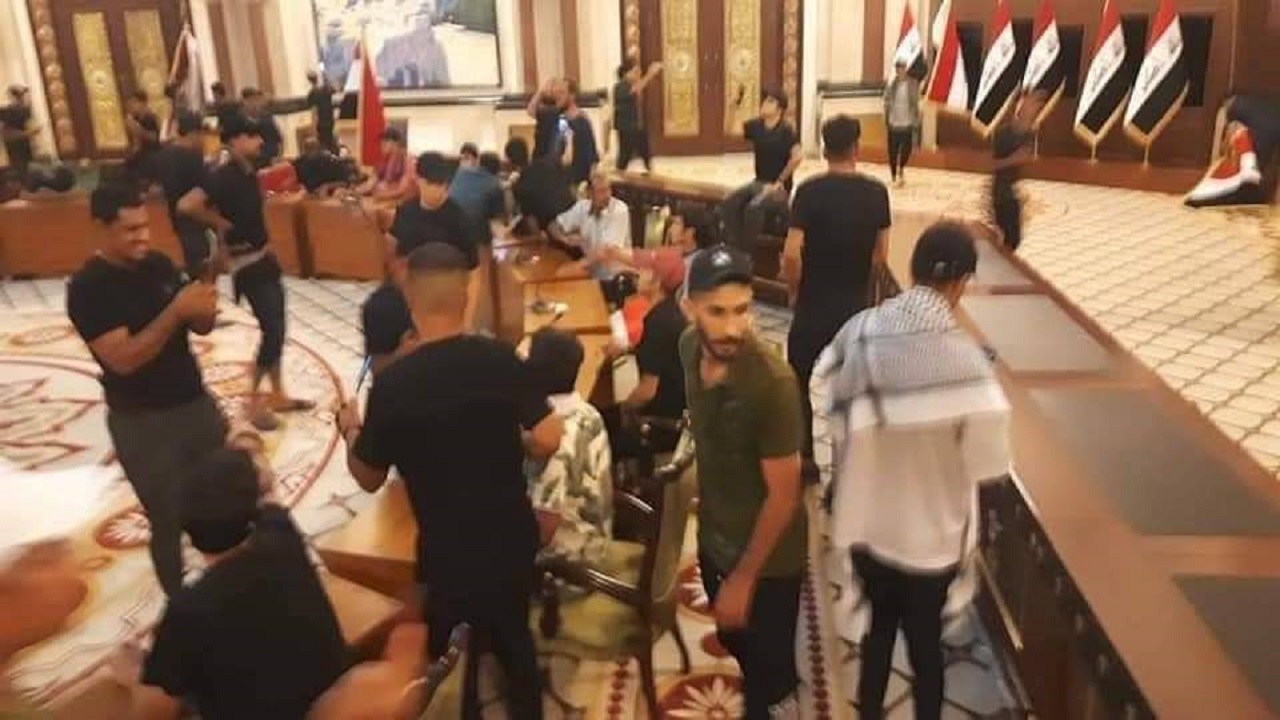 شاهد.. متظاهرون يقتحمون غرفة نوم الرئيس العراقي ويستولون على بدلته
